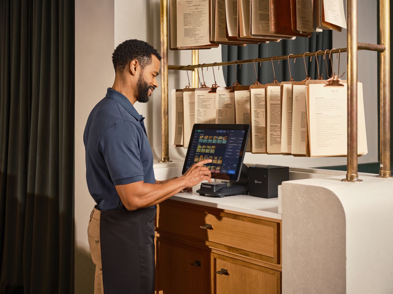 gallery-4 A restaurant server operates a touchscreen POS system, enhancing efficient order management.